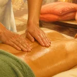 Massage du bas du dos : gestes sûrs en 10 minutes, mains sur le bas du dos avec huile amande